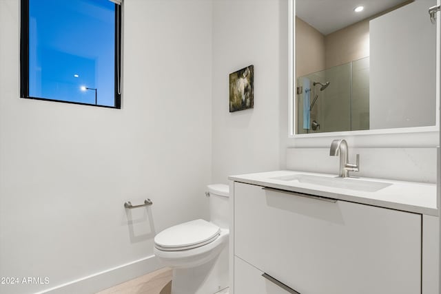 bathroom with tile patterned floors, vanity, toilet, and a shower with shower door