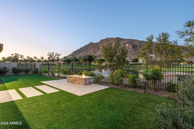 view of yard with a fire pit, a mountain view, and a patio area