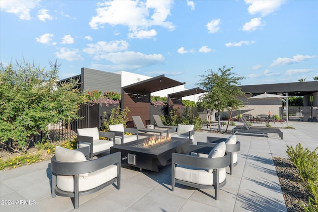 view of patio with an outdoor living space with a fire pit