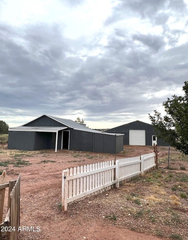 view of yard with a garage and an outbuilding