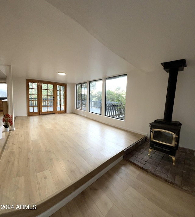 unfurnished living room featuring a wood stove and light hardwood / wood-style flooring