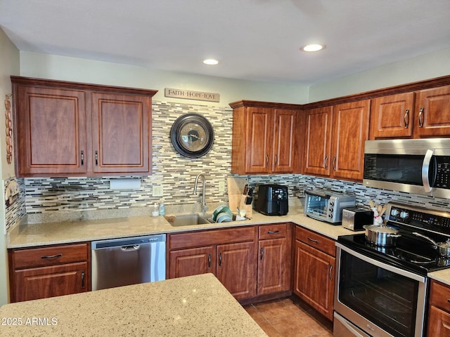 kitchen featuring sink, backsplash, light tile patterned flooring, and appliances with stainless steel finishes