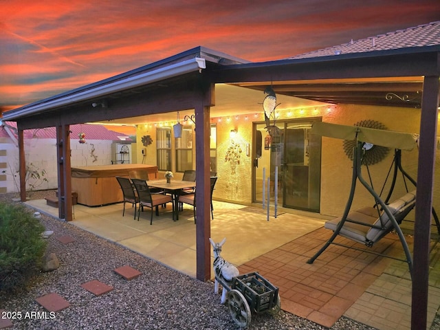 patio terrace at dusk with a hot tub