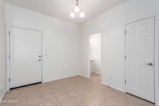 1950 N Center St Unit 115, Mesa, AZ 85201 - unfurnished bedroom with a chandelier, baseboards, connected bathroom, and light tile patterned floors