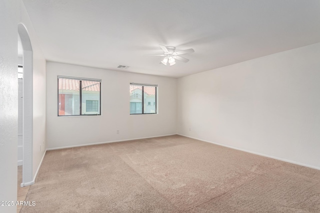 1950 N Center St Unit 115, Mesa, AZ 85201 - spare room featuring a ceiling fan, arched walkways, light carpet, and baseboards