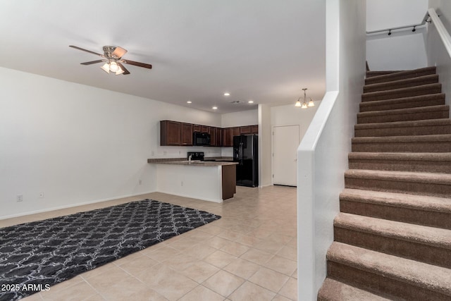 1950 N Center St Unit 115, Mesa, AZ 85201 - kitchen with black appliances, open floor plan, dark brown cabinetry, light tile patterned floors, and a peninsula