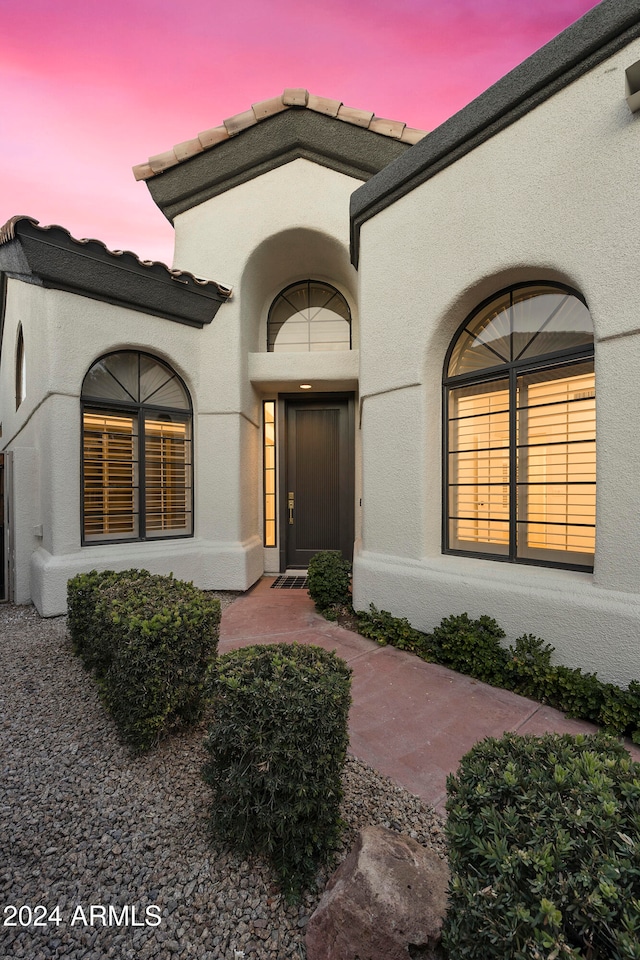 view of exterior entry at dusk