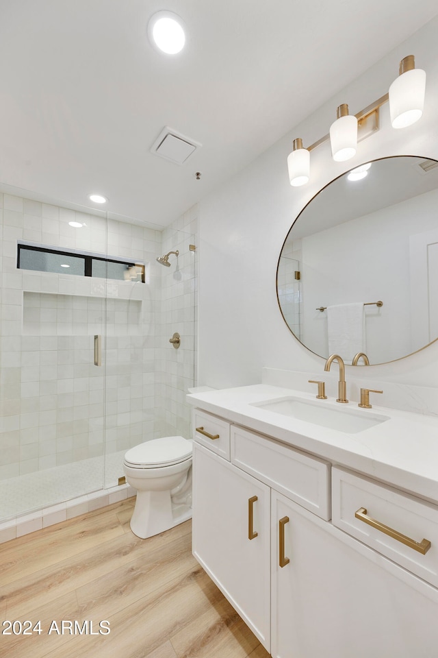 bathroom featuring hardwood / wood-style floors, vanity, toilet, and walk in shower