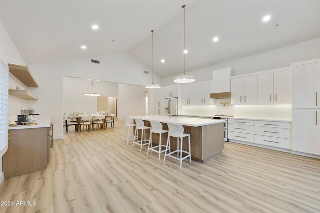 kitchen featuring custom range hood, a spacious island, light hardwood / wood-style flooring, white cabinets, and stainless steel electric range oven