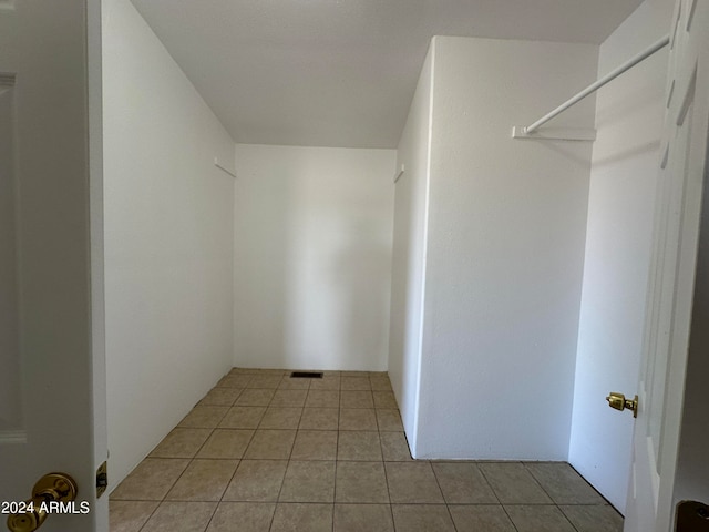 walk in closet with light tile floors