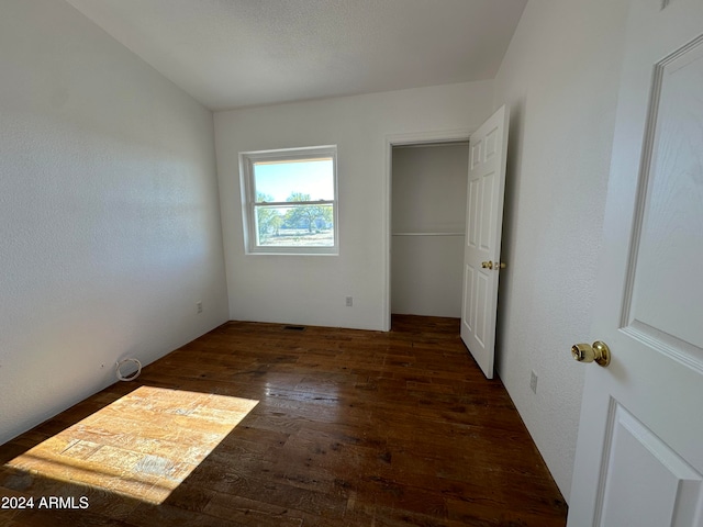 unfurnished bedroom with dark hardwood / wood-style flooring