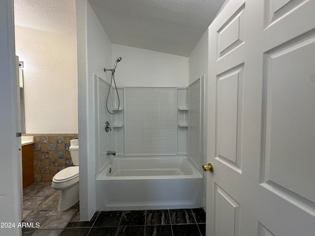 full bathroom featuring tile floors, vanity, tiled shower / bath combo, and toilet