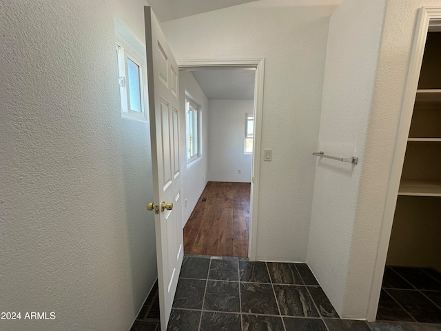 corridor featuring dark tile flooring