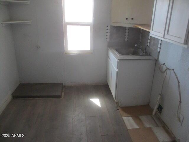 laundry room featuring light wood-style floors and a sink