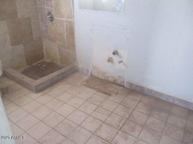 bathroom with a tile shower and tile patterned floors