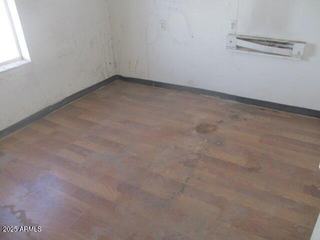 unfurnished room with baseboards and wood finished floors