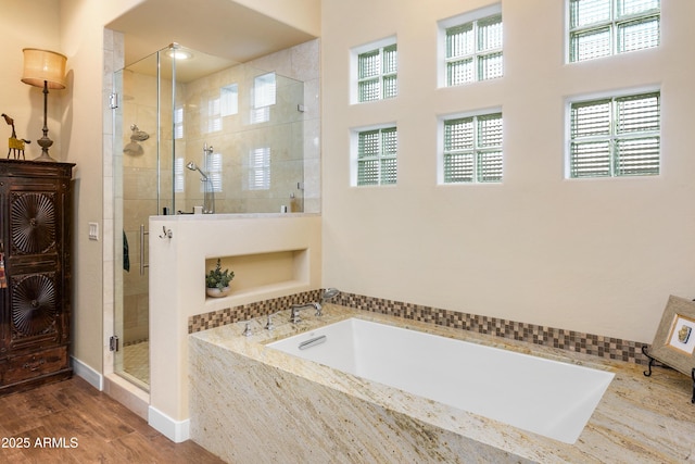 bathroom featuring separate shower and tub and hardwood / wood-style floors