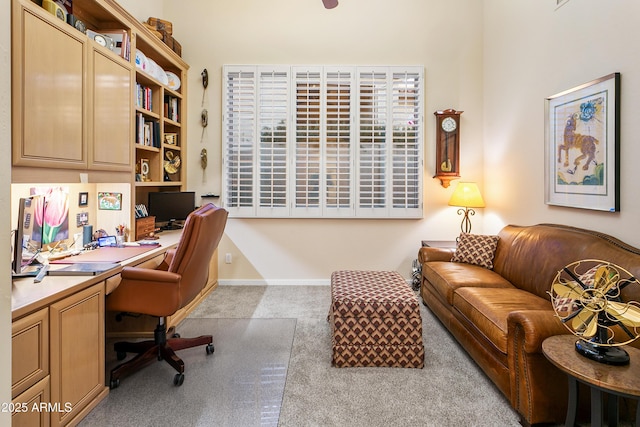 carpeted home office featuring built in desk