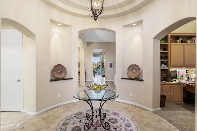 tiled entrance foyer with a chandelier