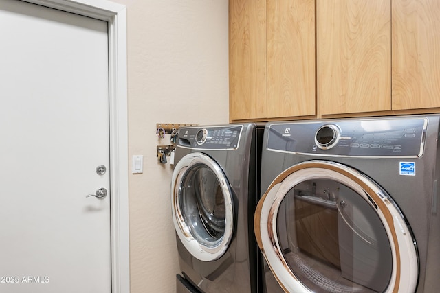 laundry room featuring cabinets and washing machine and clothes dryer