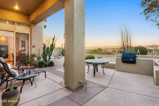 patio terrace at dusk featuring an outdoor kitchen