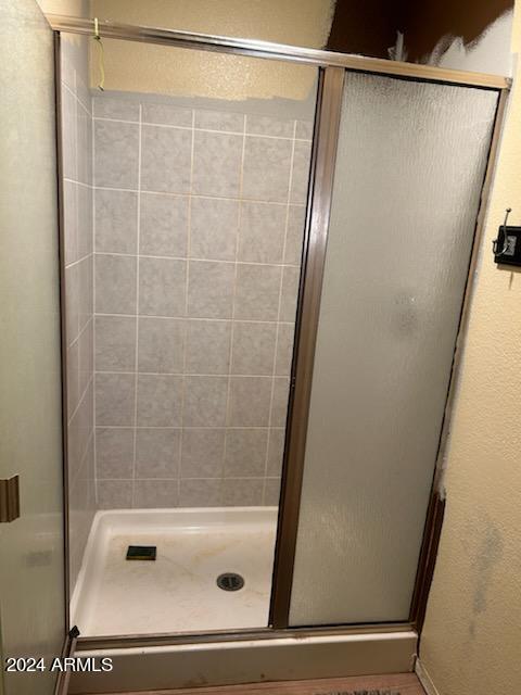 bathroom featuring a shower with door