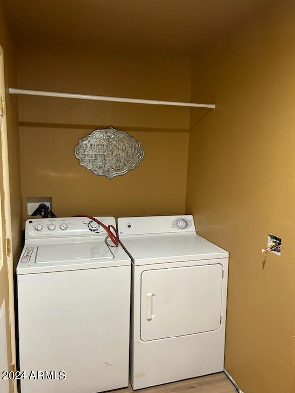 laundry room featuring light hardwood / wood-style floors and washing machine and dryer