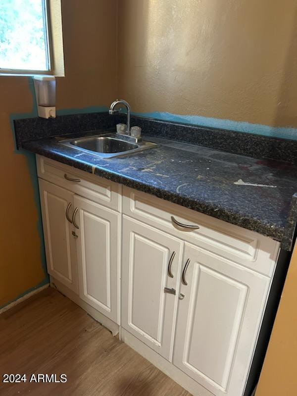 interior space featuring light wood-type flooring, white cabinetry, and sink