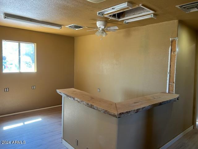 interior space featuring light wood-type flooring, ceiling fan, and a textured ceiling