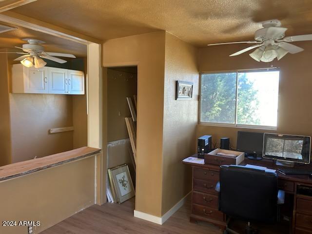 home office featuring a textured ceiling, hardwood / wood-style floors, and ceiling fan