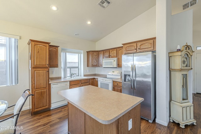 kitchen with white appliances, light countertops, visible vents, and a sink