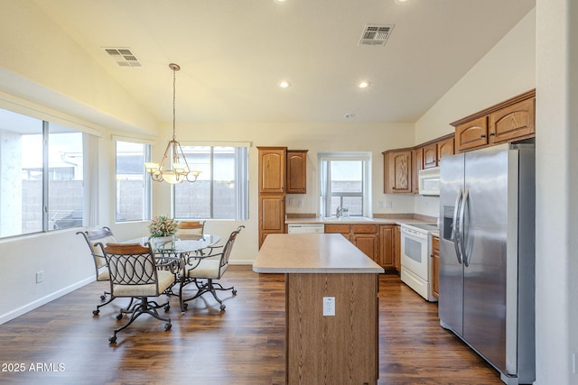 kitchen with visible vents, white appliances, light countertops, and lofted ceiling