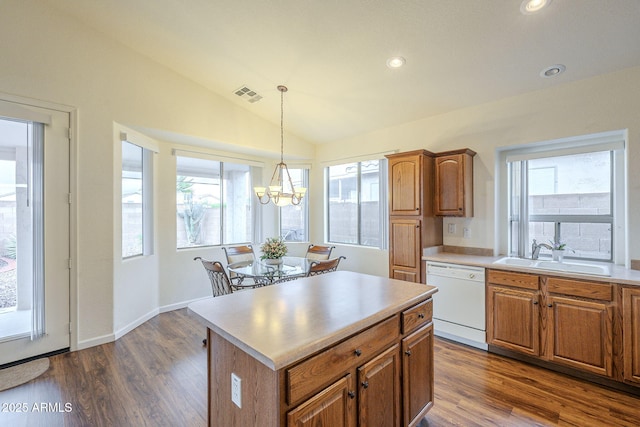 kitchen with visible vents, vaulted ceiling, white dishwasher, brown cabinetry, and a sink