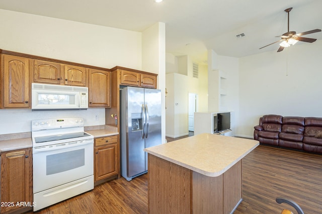 kitchen with dark wood-style floors, visible vents, white appliances, and open floor plan