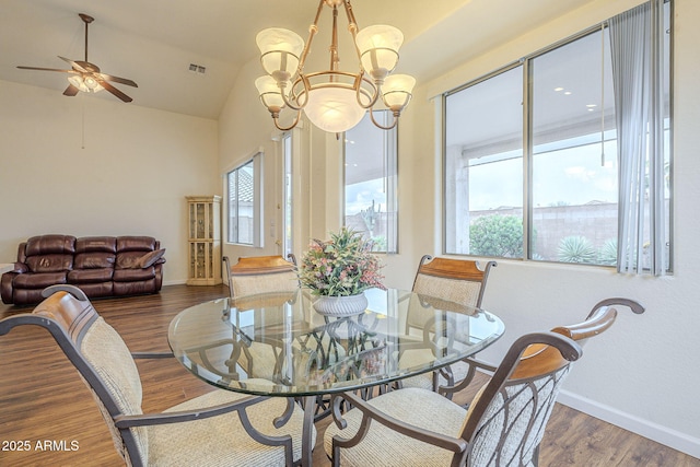 dining space with visible vents, baseboards, lofted ceiling, and wood finished floors