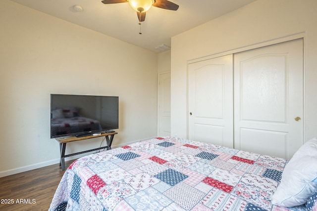 bedroom with wood finished floors, visible vents, baseboards, ceiling fan, and a closet