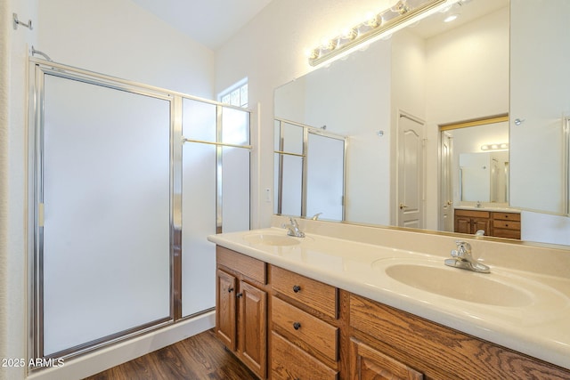 bathroom featuring a sink, wood finished floors, and a shower stall