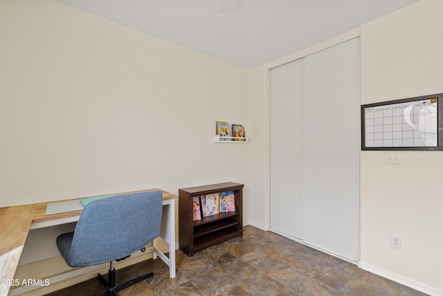 home office with stone finish flooring and baseboards