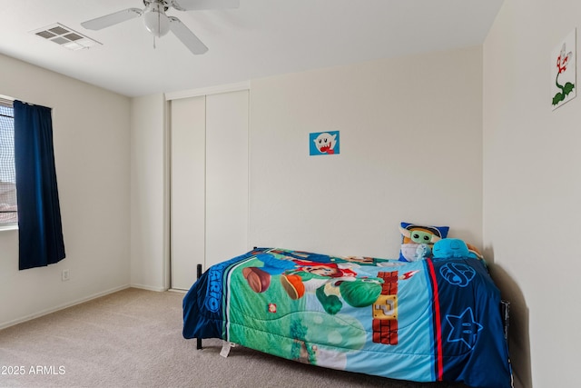 bedroom with a closet, visible vents, carpet floors, and ceiling fan