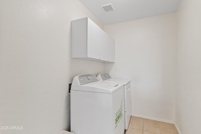 laundry room with visible vents, washer and dryer, cabinet space, light tile patterned flooring, and baseboards