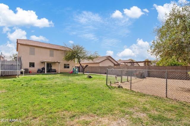 view of yard with a patio, a trampoline, and a fenced backyard