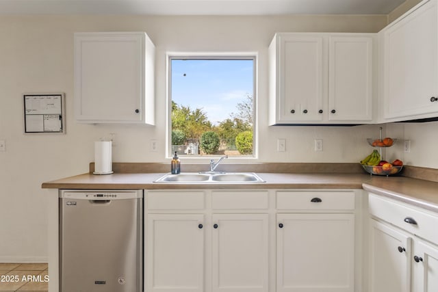 kitchen featuring a sink, stainless steel dishwasher, light countertops, and white cabinetry