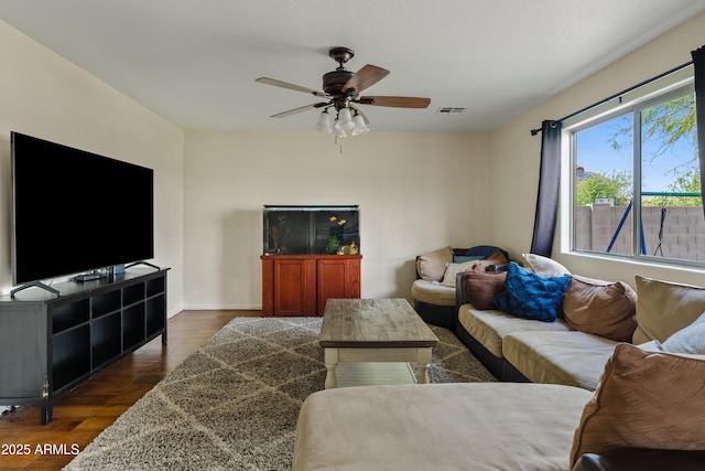 living area with visible vents, ceiling fan, and dark wood finished floors