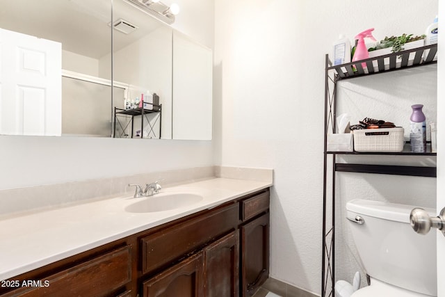 bathroom featuring vanity, toilet, and walk in shower