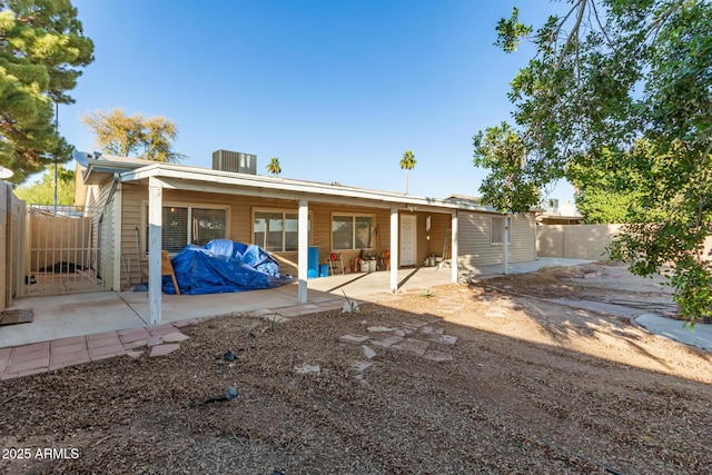 back of property with central AC and a patio