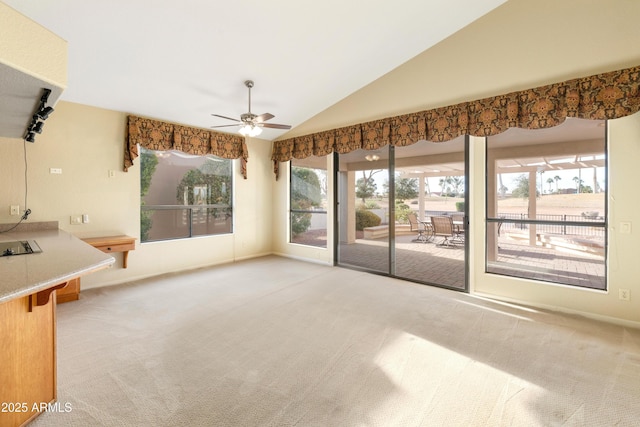 unfurnished living room featuring ceiling fan, light colored carpet, and lofted ceiling