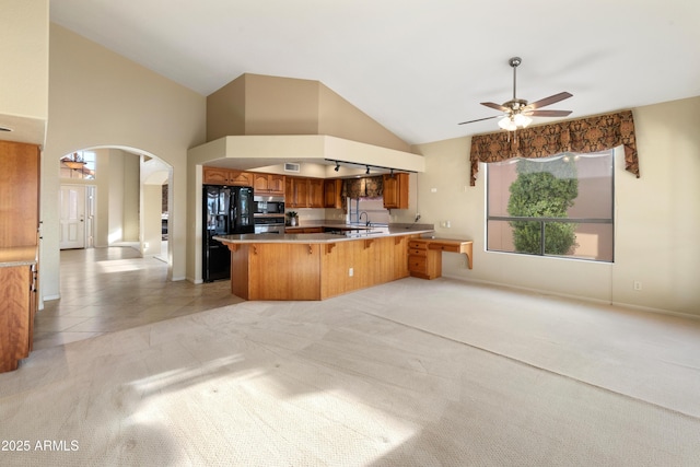 kitchen with stainless steel appliances, kitchen peninsula, high vaulted ceiling, and light carpet