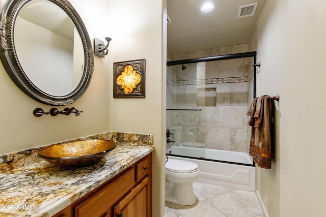 full bathroom featuring enclosed tub / shower combo, vanity, and toilet