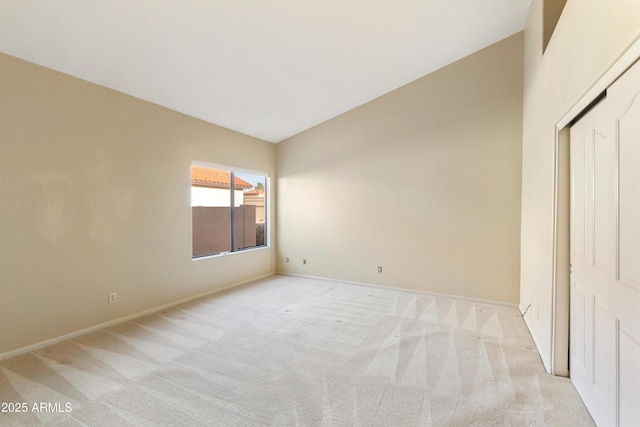 unfurnished bedroom with vaulted ceiling and light carpet