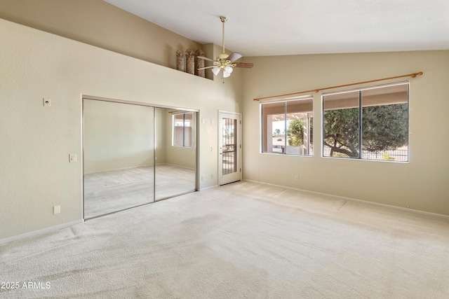 unfurnished bedroom with ceiling fan, light colored carpet, and high vaulted ceiling